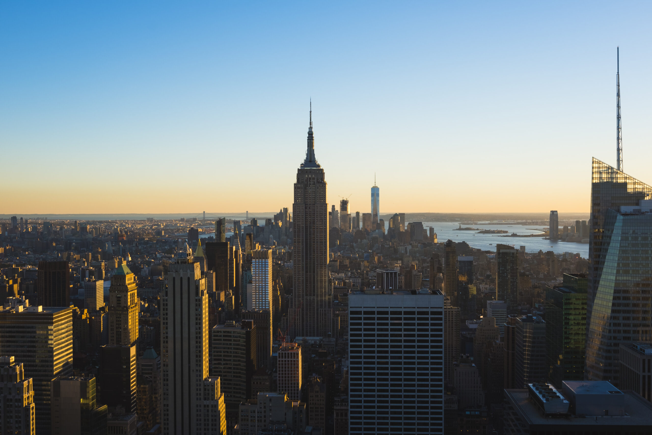 Aerial view of the Manhattan skyline at sunset, with the Empire State Building rising above the city.